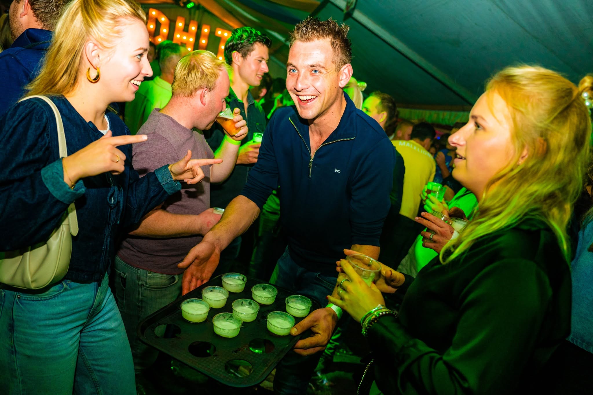 Bezoekers met een blad bier in de feesttent